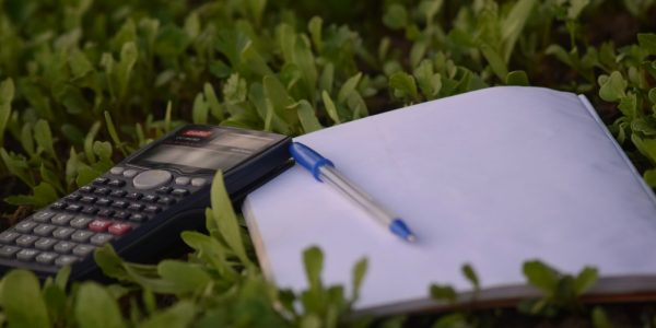 Calculator and paperwork used for budgeting a home remodel cost estimate in San Antonio