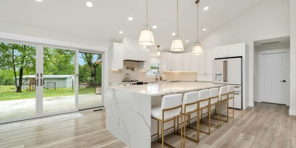 Large modern kitchen with center island and marble countertops after a San Antonio remodel