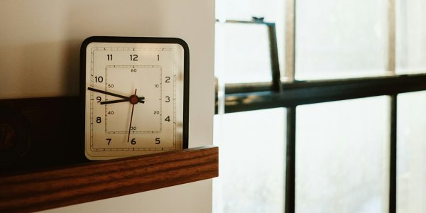 Clock on a shelf by a window as a reminder to run a home safety checklist when daylight saving time ends