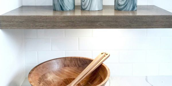 Open floating kitchen shelves with dishware in a San Antonio kitchen remodel