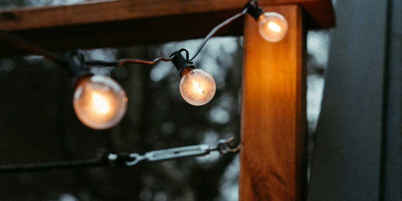 String lights glowing along a San Antonio home exterior for fall and Halloween curb appeal