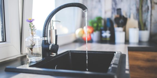 Kitchen faucet running water, relevant to San Antonio hard water and water softener installation